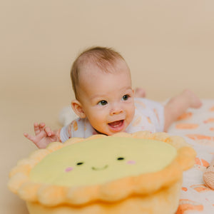 cute baby doing tummy time with the wee bean egg tart plushie toy