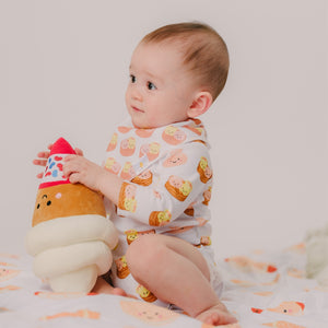 cute baby wearing the wee bean dim sum long sleeve onesie while playing with plushie