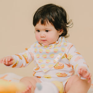 cute baby wearing the wee bean dim sum long sleeve onesie and egg tart bib