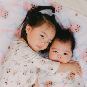 cute girl hugging baby in boba pajamas