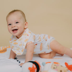 cute baby tummy time wearing the wee bean's bakery buns bib and onesie