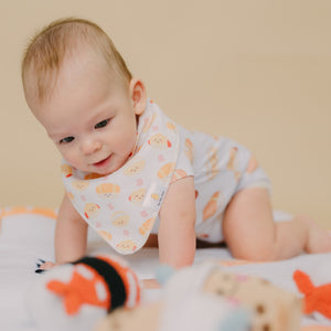 cute baby tummy time wearing the wee bean's bakery buns bib and onesie