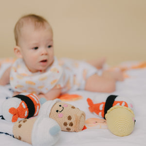 cute baby looking at the wee bean handmade rattle dolls
